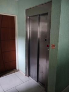 a metal elevator in a building with a door at Apartamento Mangaratiba 2 suites in Mangaratiba