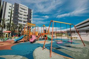 a playground with slides and swings at Waterpark Ipoh Manhattan 3BR 8pax Condo Vacation Home by City Home Empire in Ipoh