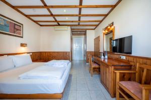 a room with two beds and a desk and a television at Palladium hotel in Marmari