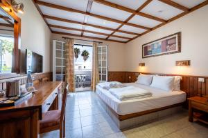 a bedroom with a bed and a desk with a computer at Palladium hotel in Marmari