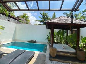 a swimming pool with a hot tub in a backyard at Belharra Villas Seminyak in Seminyak