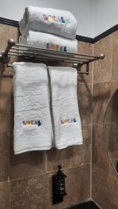 - un ensemble de serviettes sur un portant dans la salle de bains dans l'établissement LOKAL Rooms x Multan (City Center), à Multan