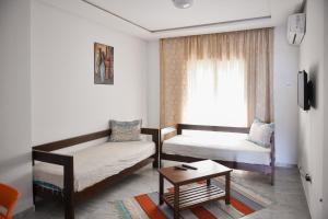 a room with two beds and a table and a window at Residence Trust in Sousse