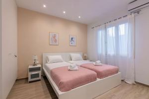 a bedroom with two beds and a window at The 626 Park Apartment in Heraklio