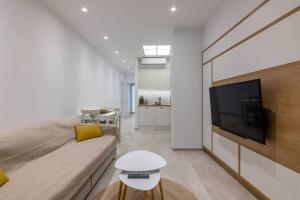 a living room with a couch and a flat screen tv at The 626 Park Apartment in Heraklio
