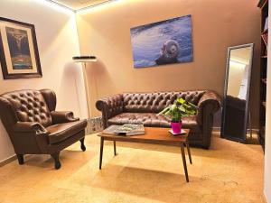 a living room with a leather couch and a table at Hotel Roca-Mar in Benidorm