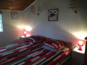 ein Schlafzimmer mit einem Bett mit zwei Lampen an zwei Tischen in der Unterkunft Le Chalet in Saint-Germain-en-Laye