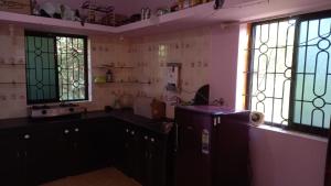 a kitchen with stained glass windows and a refrigerator at Terrace House Goa in Arambol