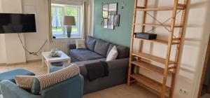 a living room with a couch and a television at Ferienwohnung 'Golsmaas' - Refugium Pottloch Ostsee in Kronsgaard