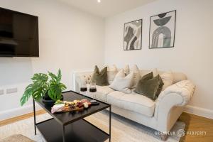 a living room with a white couch and a table at NEW Elegant apartment, 2 bed, balcony, Poole - Aurora's Abode in Parkstone