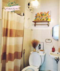y baño con aseo y lavamanos. en El Nissi Cozy Cabins (Condo Staycation Beside the Enchanted Kingdom), en Santa Rosa