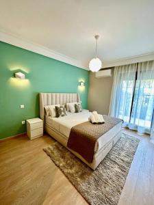 a bedroom with a bed and a green wall at Occitania - Casablanca Finance City in Casablanca