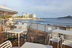 a deck with tables and chairs and the ocean at Playa Bella Beach Apartments in San Antonio Bay