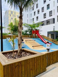 a playground with a tree and a slide at Occitania - Casablanca Finance City in Casablanca