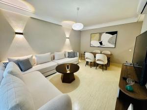 a living room with a white couch and a table at Occitania - Casablanca Finance City in Casablanca