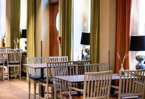 Clarion Collection Hotel Bergmästaren في فالون: غرفة طعام مع طاولات وكراسي خشبية