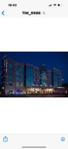 a picture of a building at night at Hotel Zhibek Zholy in Shymkent