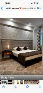 a bedroom with a large bed with a large headboard at Hotel Zhibek Zholy in Shymkent