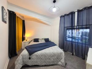 um quarto com uma cama e uma grande janela em Les Entrepreneurs - Appartements neufs et spacieux, proche RER C et Aéroport Orly em Morangis