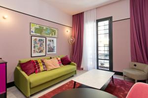 sala de estar con sofá verde y mesa en Amor de Dios 17 Boutique Apartments, en Madrid