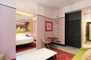 マドリードにあるAmor de Dios 17 Luxury Suitesのベッドルーム1室(ベッド1台、テーブル、テーブルサイドシックスシックス付)