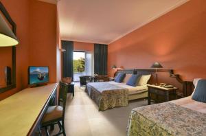 a hotel room with two beds and a couch at Hotel Schuhmann in Paestum