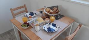 a table with plates and eggs and a basket of bread at B&B t'bûtefjild in De Valom