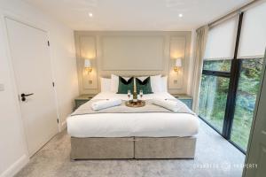 um quarto com uma cama grande e uma janela grande em NEW Elegant apartment, 2 bed, balcony, Poole - Aurora's Abode em Parkstone