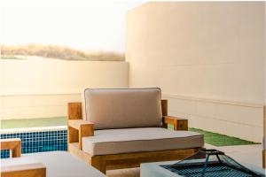 a chair sitting in a room with a window at Voyage Private Pool & Beach At Your Doorstep in Abu Dhabi