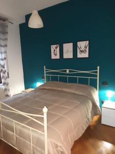 una camera da letto con un letto con una parete blu di La casa di Elenù a Posillipo a Napoli