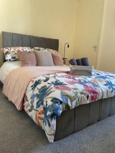 a bedroom with a large bed with a colorful comforter at The Butcher's Flat Seahouses in Seahouses