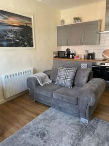 a living room with a couch and a kitchen at The Butcher's Flat Seahouses in Seahouses