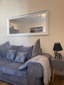 a living room with a blue couch and a mirror at The Butcher's Flat Seahouses in Seahouses