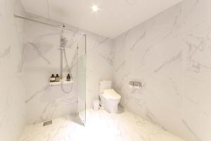 a white bathroom with a shower and a toilet at HOUND HOTEL sasang branch in Busan +107 photos