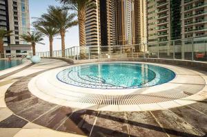 a large swimming pool in a building with tall buildings at Maison Privee - Modern Urban Retreat in the Heart of Dubai Marina in Dubai