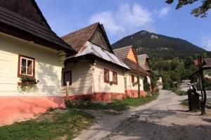 a group of houses with mountains in the background at Drevenica Baltazár in Liptovská Lúžna