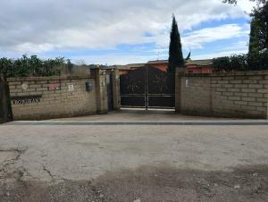 een garage met een zwarte poort en een stenen muur bij Tenuta Quadrone in Cura
