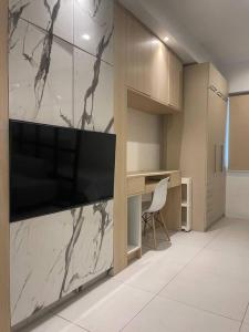 ダバオシティにあるStudio unit in Prime Locationのデスク、壁掛けの大型テレビが備わる客室です。