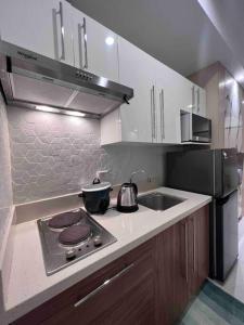 a kitchen with a stove top and a sink at Studio unit in Prime Location in Davao City