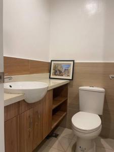 a bathroom with a white toilet and a sink at Studio unit in Prime Location in Davao City