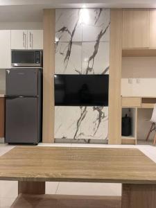 a kitchen with a black refrigerator and a marble wall at Studio unit in Prime Location in Davao City
