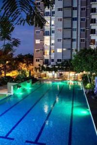 a swimming pool with green lights in front of a building at Studio unit in Prime Location in Davao City