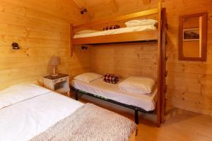 dwa łóżka piętrowe w drewnianej kabinie z lampką w obiekcie Le Petite Chalet Tourmente w Chamonix-Mont-Blanc