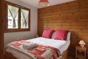 um quarto com uma cama com almofadas vermelhas em Les Capucins - Calm - Mont-Blanc - Lake Gaillland em Chamonix-Mont-Blanc