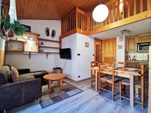 ein Wohnzimmer mit einem Tisch und einer Küche in der Unterkunft Clos du Savoy - Chamonix Center - Skii on foot in Chamonix-Mont-Blanc