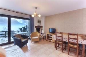 een woonkamer met een tafel en stoelen en een televisie bij Le Crétet 2 - Best views of the Mont-Blanc in Chamonix-Mont-Blanc