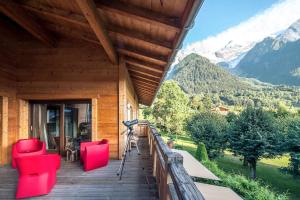 weranda z czerwonymi krzesłami i widokiem na góry w obiekcie L'écrin des Bossons w Chamonix-Mont-Blanc