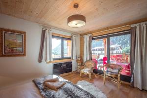 a living room with a couch and a large window at L'écrin des Bossons in Chamonix-Mont-Blanc