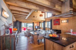 a kitchen and living room with wooden walls and wooden floors at L'écrin des Bossons in Chamonix-Mont-Blanc