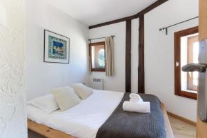 - une chambre avec un lit blanc et une serviette blanche dans l'établissement Nook 43 The Corner Central 3 bedroom Apt, à Chamonix-Mont-Blanc